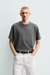 Camiseta regular fit de color beige, confeccionada en tejido de algodón compacto, con cuello redondo y manga corta.
