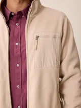 Campera de polar color verde militar, con cierre frontal completo, cuello alto y bolsillo en el pecho con cierre y detalle en tela técnica.