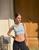 Remera corta sin mangas, con cuello polo y estampado a rayas horizontales en tonos celeste y blanco.