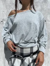 Buzo de cuello bote confeccionado en tela angorina elastizada, con diseño de hombros caídos y ajuste en la cintura.