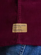 Camisa de pana color azul marino, con mangas largas, cuello clásico y dos bolsillos frontales con solapa y botón.