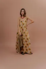 Vestido largo de tirantes finos, con escote en V y estampado de girasoles sobre fondo beige.