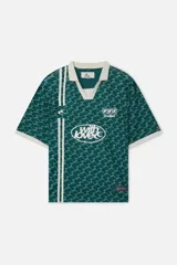 Camiseta tipo polo de Scuffers, color verde con estampado monograma y detalles en blanco en el cuello, los puños y los gráficos frontales de estilo deportivo vintage.