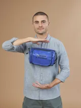 Neceser azul con cierre superior y correa de mano. Estampado con el logo "Benson & Thomas" en el frente.