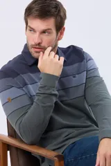 Remera polo de manga larga con diseño rayado en degradado de tonos azules y grises, cuello liso azul marino y logo bordado en el pecho. Confeccionada en tejido piqué de algodón.