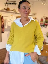 Sweater de punto color amarillo mostaza, con escote en V amplio y mangas largas de corte holgado.