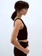 Top negro de tejido acanalado, corte cropped y escote bote, sin mangas.