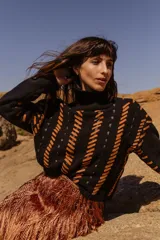 Sweater tejido a mano de algodón negro con cuello alto y detalles de cuero natural color naranja. Puños y ruedo acanalados.