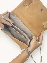 Sobre de cuero color camel con aplique de cuero con estampado animal print. Tiene forro interior y cadena metálica extraíble.