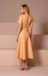 Falda midi color beige de cuero sintético, corte evasé y cintura alta.