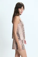 Conjunto de pijama compuesto por una musculosa con breteles finos y detalle de encaje en el escote, y un short corto. Presenta un estampado animal print de serpiente en tonos tierra.