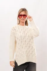 Sweater de punto color crema con cuello redondo y mangas largas.