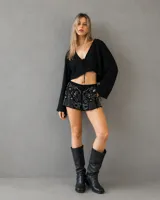 Short negro con bordados florales en contraste y detalles brillantes. Presenta un diseño de tiro medio con calce cómodo.