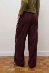 Pantalon de corte recto y pierna ancha, confeccionado en tejido tipo denim oscuro. Presenta tiro alto, cintura con cierre frontal y bolsillos laterales funcionales.