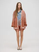 Cardigan de punto con diseño degradé en tonos tierra, patrón de rombos en relieve, cuello en V con cartera de botones y puños con rayas blancas y marrones.