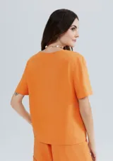 Blusa naranja de lino con escote en V y mangas cortas.