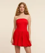 Vestido corto con pollera balonê, escote sin breteles, cierre por cremallera en el lateral y confeccionada en viscolino.