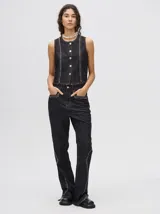 Pantalón de denim tiro alto con corte ochentoso y terminación oxford. Presenta apliques metalizados decorativos en los bolsillos delanteros y a lo largo de la parte externa de las piernas.