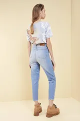 Pantalón de jean celeste con roturas en las rodillas, corte mom fit y tiro alto.