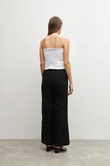 Pantalón negro de lino, de corte ancho y tiro alto, con tajo lateral en el ruedo.