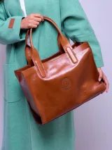 Cartera de cuero color marrón con compartimiento interno removible y logo circular en el frente.