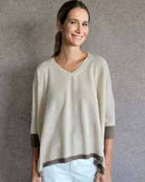 Sweater beige de lana lambswool con cuello en V y mangas 3/4 con puños en marrón.