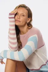 Buzo de tejido fino con rayas horizontales en tonos rosa, blanco y celeste, confeccionado en algodón.