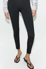 Leggings de tiro alto confeccionados en tejido de poliamida, con diseño ajustado y detalle de aplicación de encaje a tono en los tobillos.