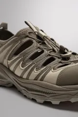 Sandalia deportiva negra con aberturas laterales para ventilación, puntera reforzada, ajuste con cordones y suela de goma.