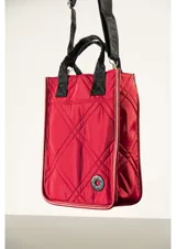 Bolso matero de diseño vertical con efecto capitoné y costuras romboidales, color verde militar. Cuenta con manijas cortas superiores y una correa ajustable para el hombro con la inscripción de la marca. Incluye un pequeño aplique circular con logo en la parte inferior.
