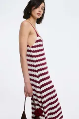 Vestido midi de tejido de punto con diseño de rayas horizontales en color bordó y blanco. Presenta escote en V, breteles finos ajustables y una silueta fluida y cómoda.