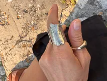 Anillo abierto de diseño rústico y orgánico, con textura irregular que evoca la naturaleza. Realizado artesanalmente en metal.