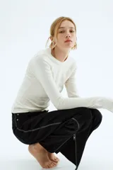 Remera entallada de manga larga y cuello redondo, color blanco crudo.