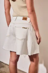 Bermuda de denim color blanco con costuras en contraste, tiro medio y ruedo desflecado.
