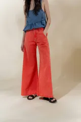 Pantalón de jean color naranja, de tiro medio y corte ancho.