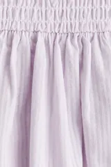 Vestido midi sin mangas confeccionado en sirsaca de algodón color lila, con cuerpo ajustado de punto smock, escote redondo y falda amplia con vuelo y costura fruncida en la cadera.