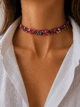 Gargantilla tipo choker con base fucsia, decorada con una incrustación de piedras multicolor y pequeños detalles brillantes.