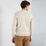 Sweater color beige claro de tejido de punto liso con cuello redondo y mangas largas.