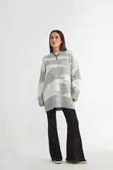 Buzo de punto con diseño estampado abstracto en blanco y negro, de corte holgado, cuello redondo y mangas largas con puños acanalados.