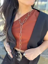 Collar largo de eslabones ovalados plateados, con un mecanismo que permite usarlo como collar largo, doble corto o en forma de corbatín.