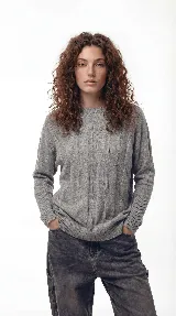 Sweater de punto con textura de ochos verticales, cuello redondo, mangas largas con puños acanalados y silueta relajada.