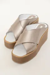 Sandalias con plataforma de goma eva color visón, confeccionadas en cuero vacuno y hechas a mano en Uruguay. Presentan tiras cruzadas en el empeine y suela de goma. La plataforma mide 7 cm de alto.