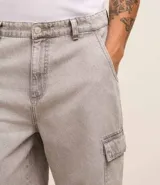 Bermuda de hombre en denim de algodón, modelo cargo, corte baggy y tiro medio. Presenta bolsillos laterales tipo cargo y cierre tradicional con botón y cremallera.