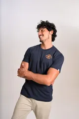 Remera de cuello redondo y manga corta en color azul marino, con estampado pequeño en el pecho que incluye el texto New York City 1955 Original en color naranja.