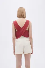 Top tipo chaleco de corte entallado, con escote en V y cierre frontal con botones a tono.
