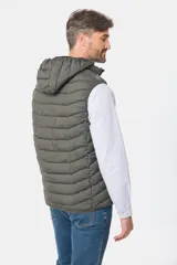 Chaleco capitoneado de color verde militar, con cierre frontal y capucha desmontable. Presenta un diseño acolchado con costuras horizontales y logo bordado en el pecho.