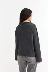 Sweater de tejido de punto acanalado en color gris, con cuello alto y mangas largas con diseño oxford acampanado.