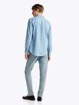 Camisa de denim celeste de Tommy Hilfiger de corte regular, con cuello abotonado, manga larga con puños abotonados, bolsillo de parche en el pecho y logo bordado en el bolsillo.