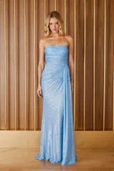 Vestido largo de fiesta celeste con escote strapless, drapeado en el busto y falda con caída lateral.