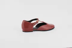 Zapato flat color ladrillo de cuero, con corte en forma de T y hebilla dorada.